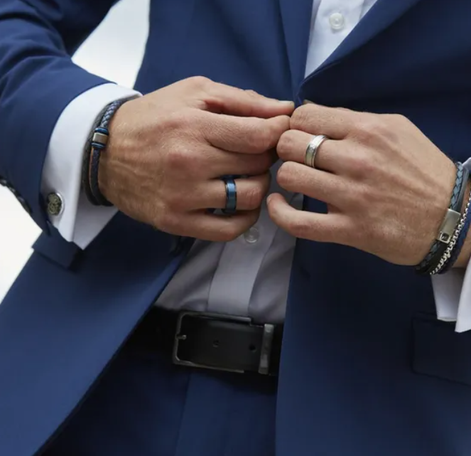 A man in a blue suit adjusts his TUNGSTEN RING BLACK TUR-118 BY UNIQUE & CO.