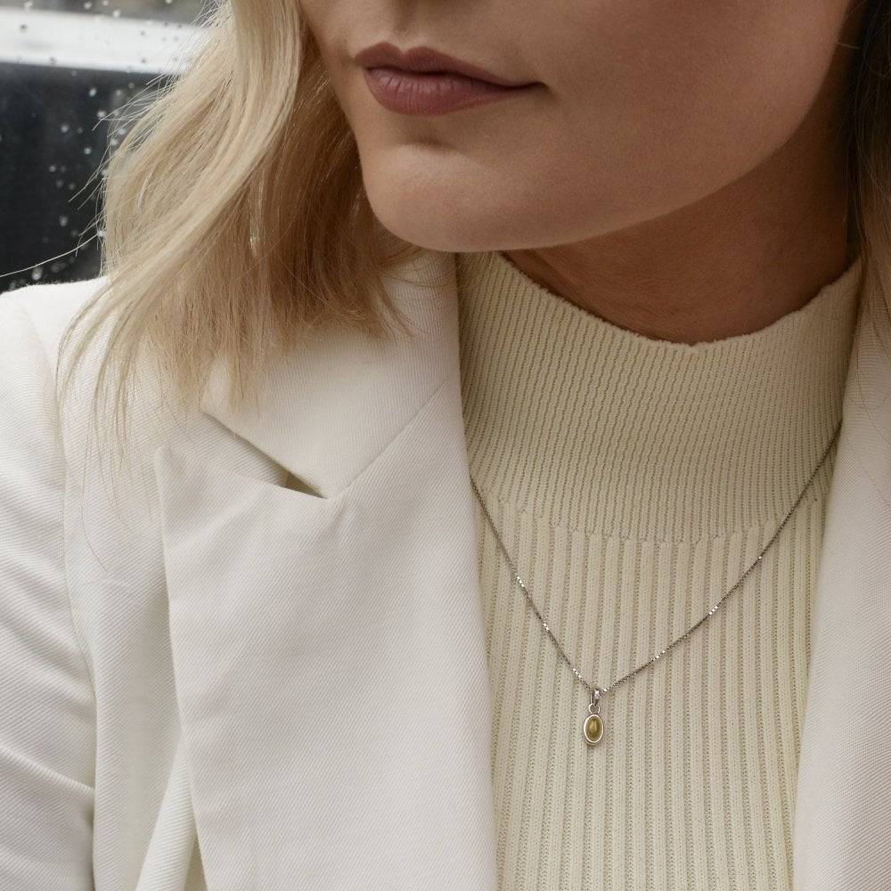 A woman wearing a white jacket and a Birthstone Necklace November – Citrine.