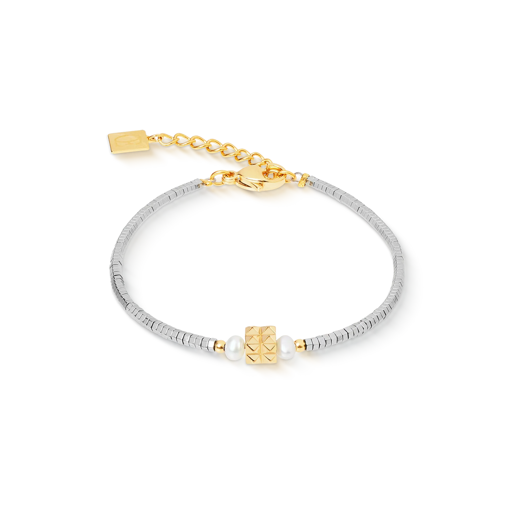 The Couer De Lion Bracelet Edge & Grace silver-gold is a handcrafted piece featuring a gold square bead with a studded pattern, freshwater pearls, silver-toned discs, and an adjustable gold clasp with tag.