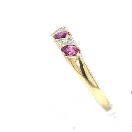 This Pre-loved Ruby & Diamond Half Eternity Dress Ring in 9ct yellow gold features two marquise-cut rubies and two small diamonds set diagonally along the band.