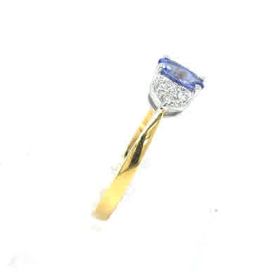 Tanzanite and Diamond Cluster Dress Ring in 18ct yellow gold, showcasing a central blue tanzanite encircled by sparkling diamonds, set against a plain white background.