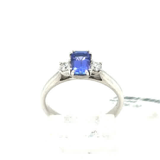 A stunning Tanzanite and Diamond Trilogy Dress Ring in 9ct white gold, featuring a rectangular tanzanite gemstone flanked by sparkling diamonds for added elegance.