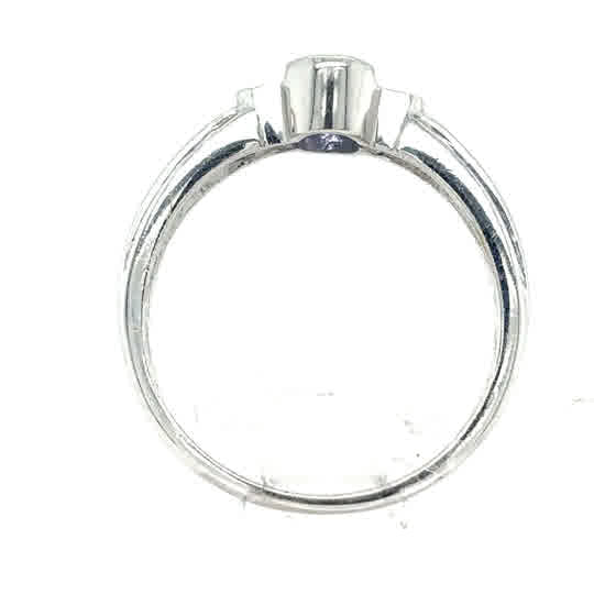 The Tanzanite Trilogy Dress Ring in 9ct white gold features an empty prong setting, viewed from the side—ideal for mounting a gemstone and crafting a beautiful oval-cut tanzanite centerpiece.