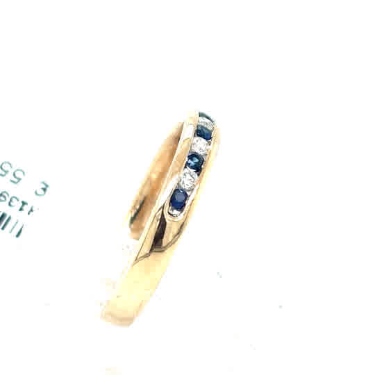 The Sapphire & Diamond Half Eternity Dress Ring in 9ct yellow gold features alternating blue sapphires and diamonds set diagonally across the band.