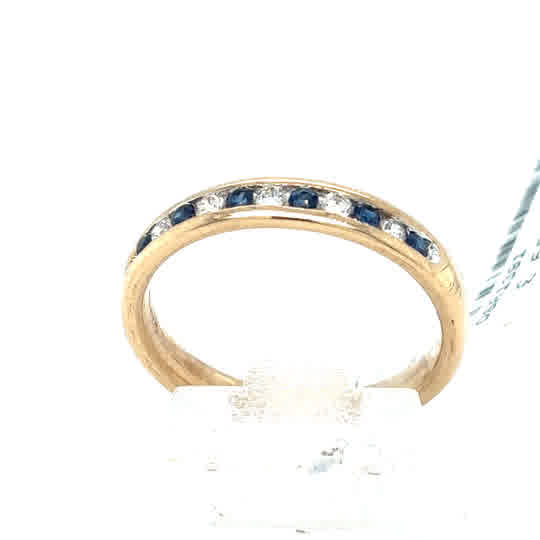 The Sapphire & Diamond Half Eternity Dress Ring in 9ct yellow gold features alternating sapphire and diamond stones, shown upright against a white background.