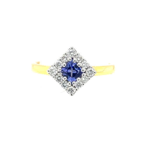 The Tanzanite and Diamond Cluster Dress Ring in 18ct yellow gold features a striking tanzanite centerpiece framed by sparkling diamonds.
