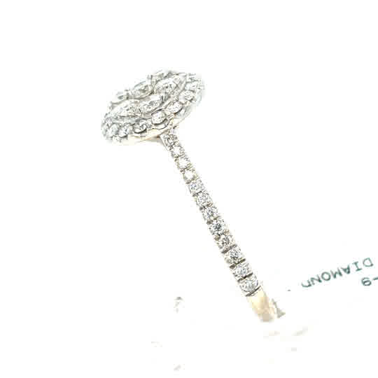 The Starburst Canadian Diamond Round Engagement Ring in 9ct White Gold features a multi-layered diamond cluster centerpiece and pavé set diamonds along the band.