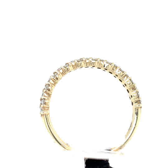 The Starburst Canadian Diamond Half Eternity Ring in 9ct yellow gold features a row of baguette-cut clear stones along the top half, displayed against a white background.