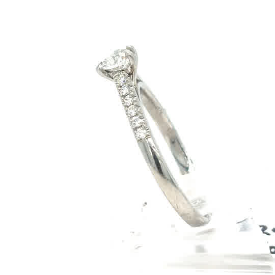 A pre-loved Platinum Heart Diamond Engagement Ring with sparkling diamonds on the band, elegantly displayed against a white background.