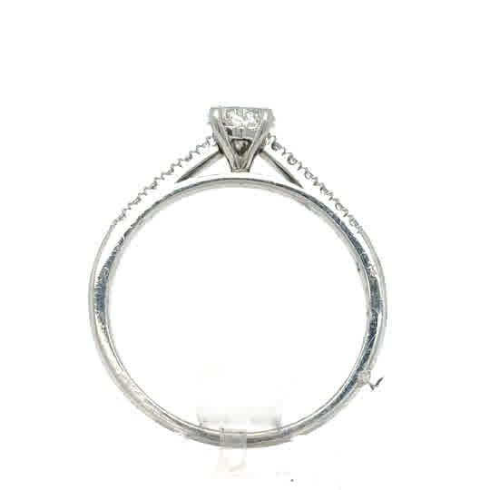 Side view of the Platinum Heart Diamond Engagement Ring, showcasing a single round diamond in a prong setting with small accent stones on the band.