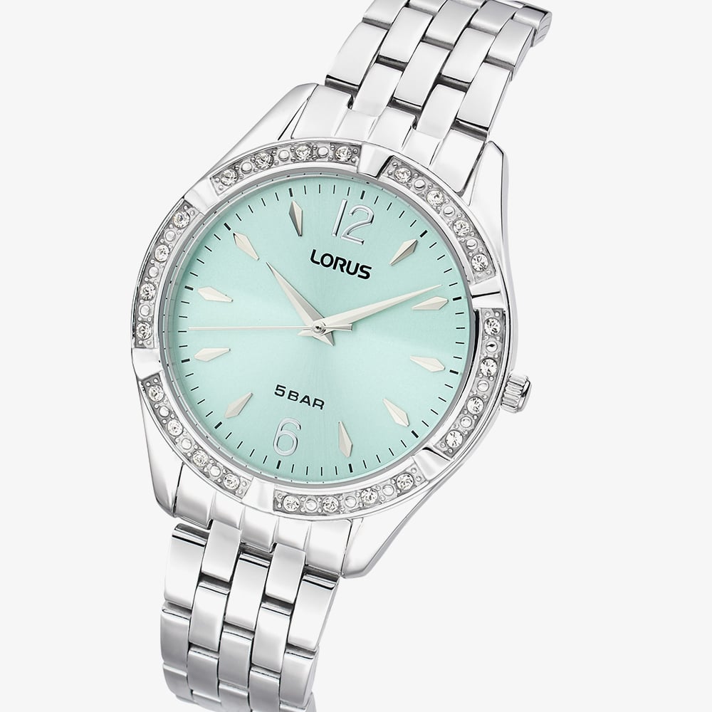 The Lorus Women’s Stainless Steel Quartz Watch RG263WX9 features a light blue sunray dial, silver hour markers, crystal-studded bezel, and a sleek metal link band—an elegant choice for any occasion.