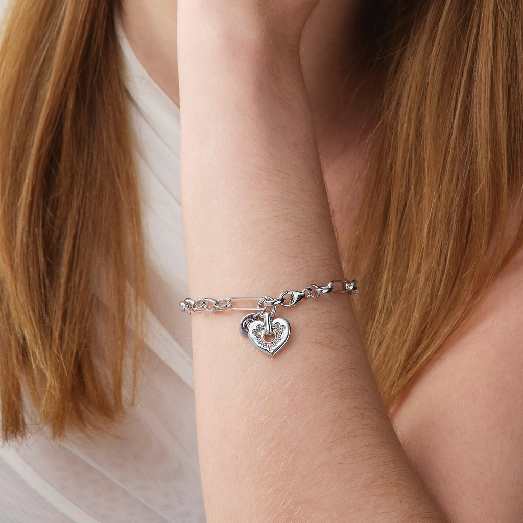 A person with long hair wears the Clogau Cariad® Sterling Silver Sparkle Figaro Bracelet with Topaz on their wrist, paired with a light-colored, sleeveless top.