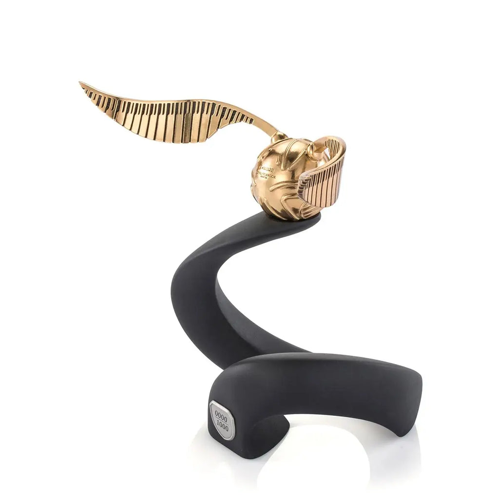 The Harry Potter Limited Edition Golden Snitch Replica is a 24K gold collectible displayed on a sleek black stand with a small plaque at the base.