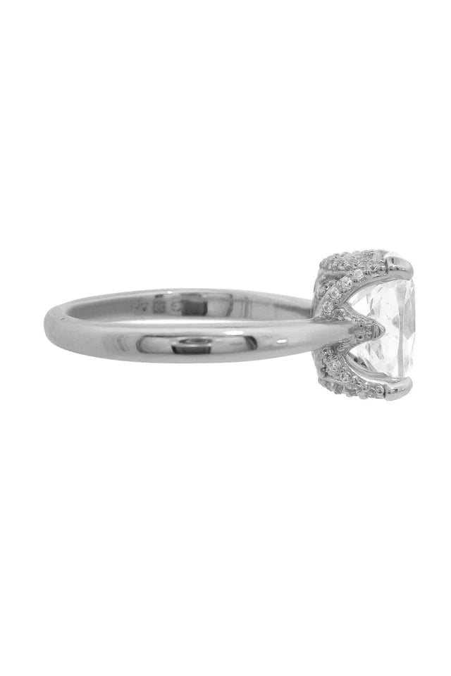 Side view of the Georgini Sydney Soirée Elaine Cushion Cut Ring Silver, crafted from rhodium plated 925 sterling silver, featuring a large clear cushion cut stone with small accent stones set on the band near the setting.