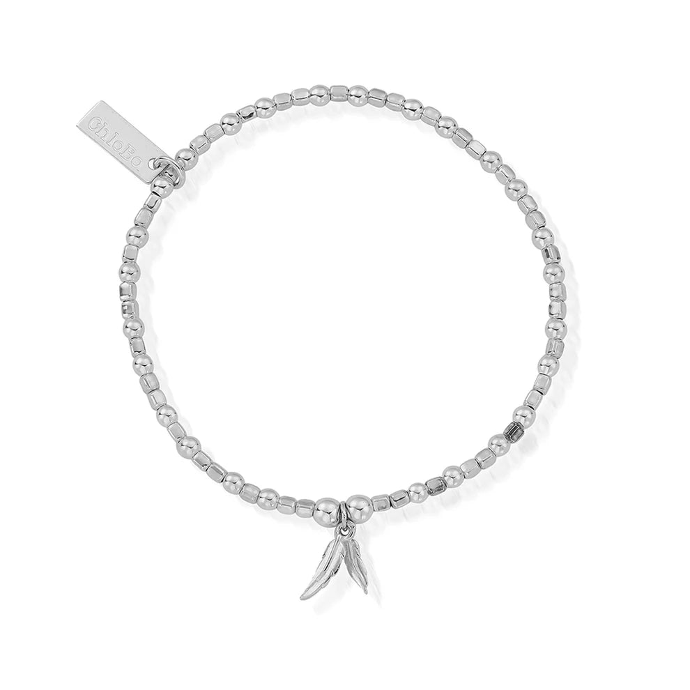 The ChloBo Mini Cube Double Feather Bracelet features silver beads, a double feather charm, and a small rectangular tag—making it a meaningful gift.