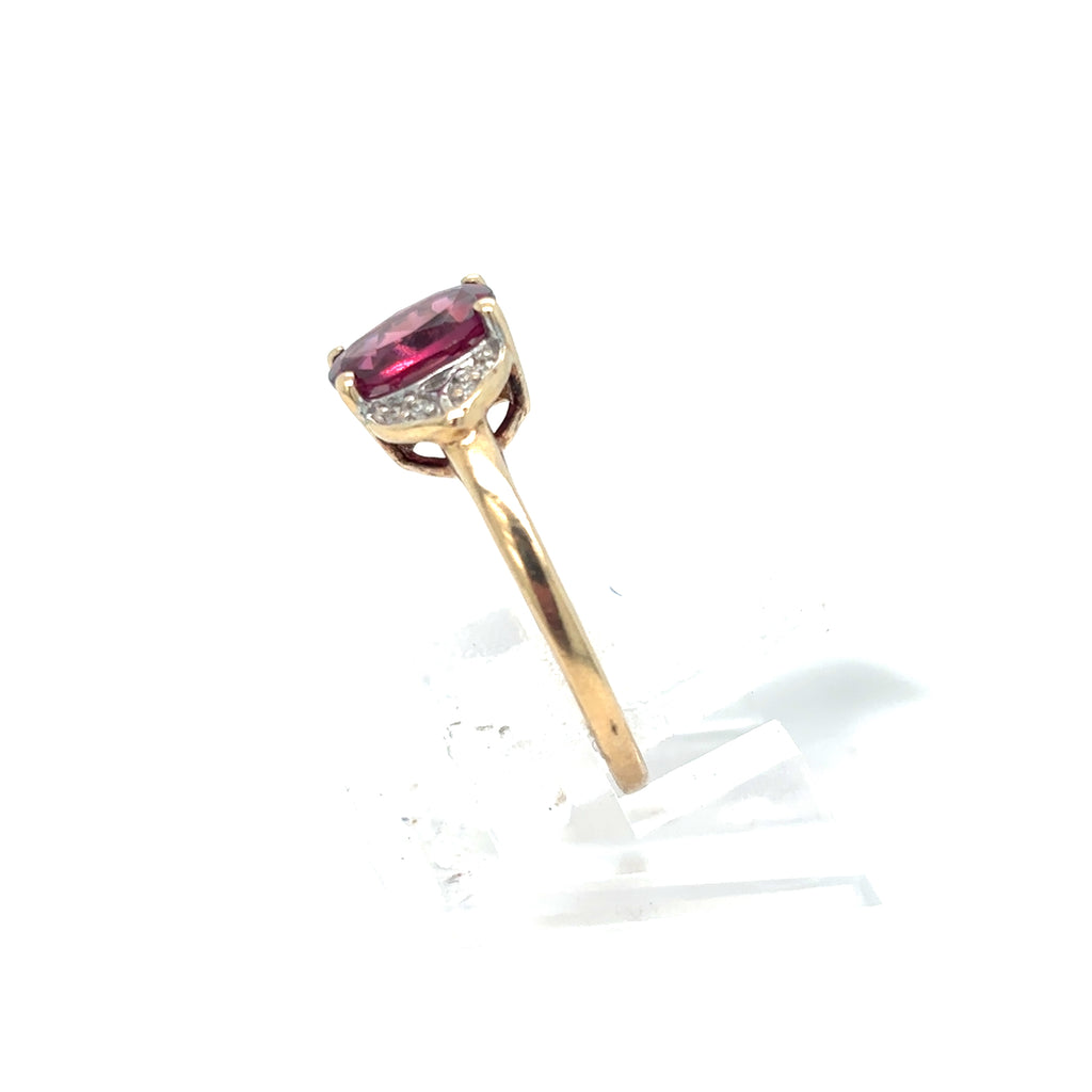 Gold ring with a pink gemstone on a white background