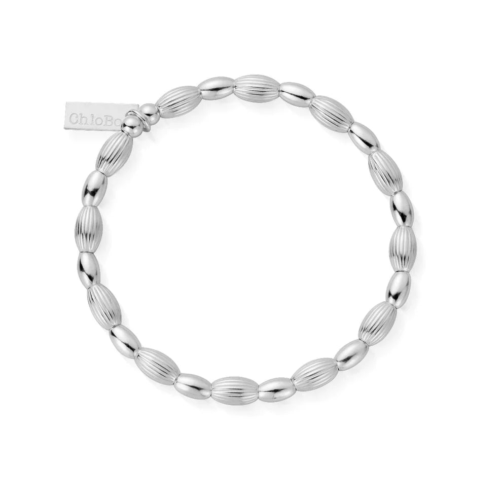 The ChloBo Double Rice Bracelet is a minimalist piece with alternating smooth and ridged oval beads and a small rectangular tag near the clasp.