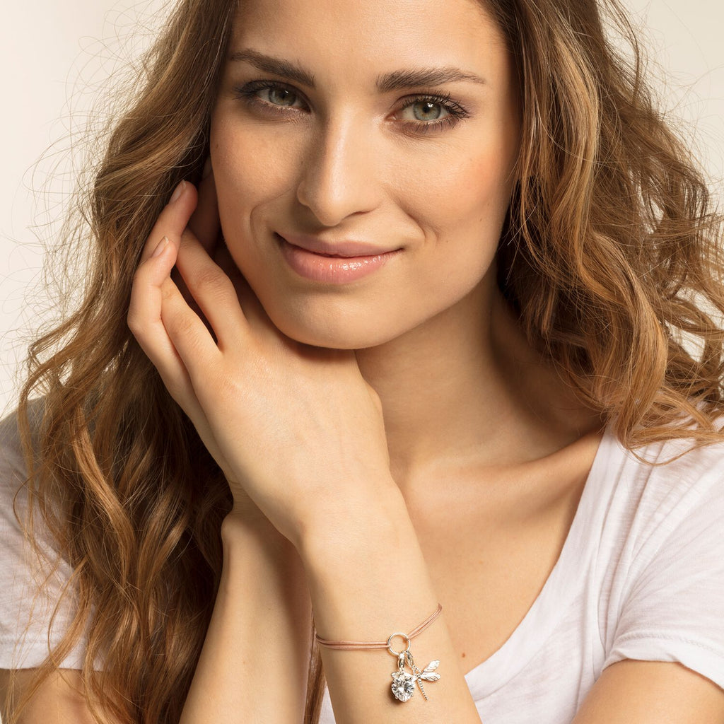 A young woman wearing a Dragonfly Charm Pendant with a butterfly charm.