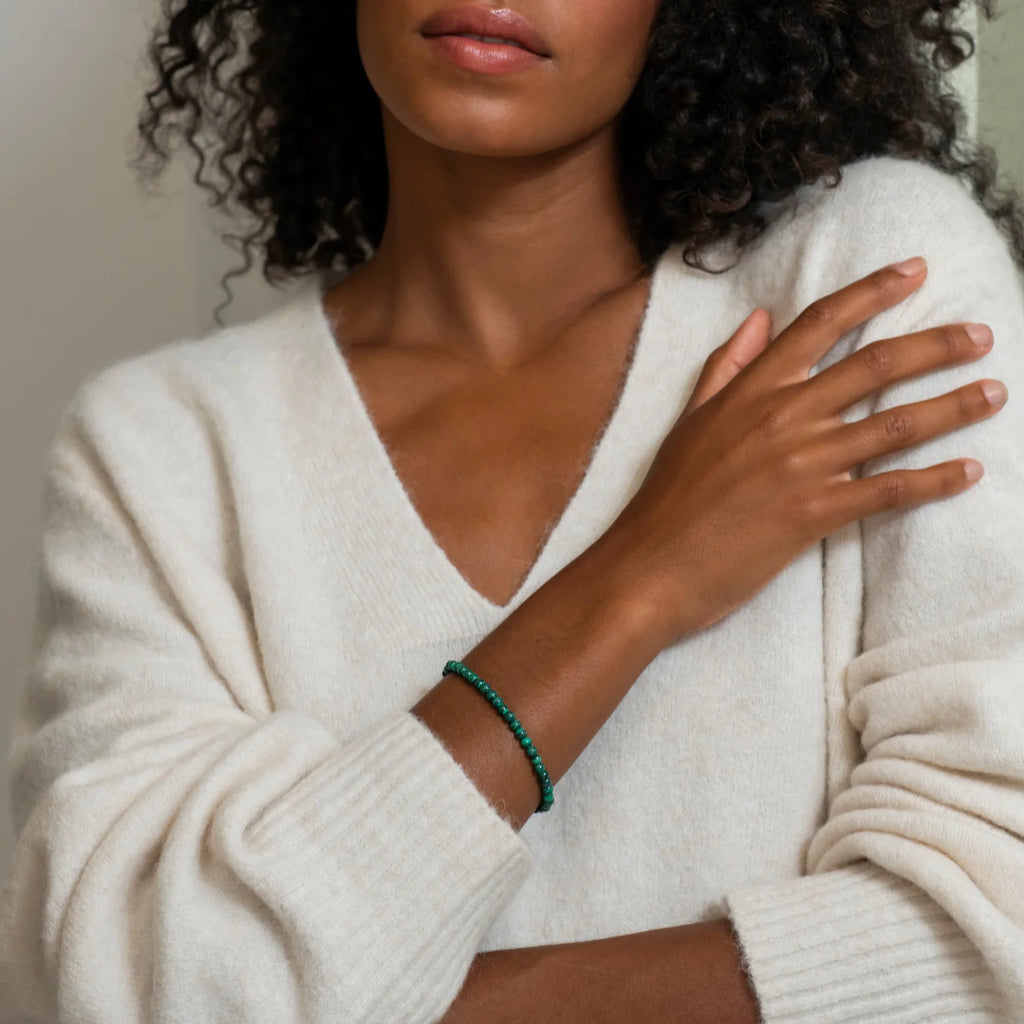 A woman with curly hair wearing a white sweater and TI SENTO – Milano Malachite Green Bracelet 2908MA.