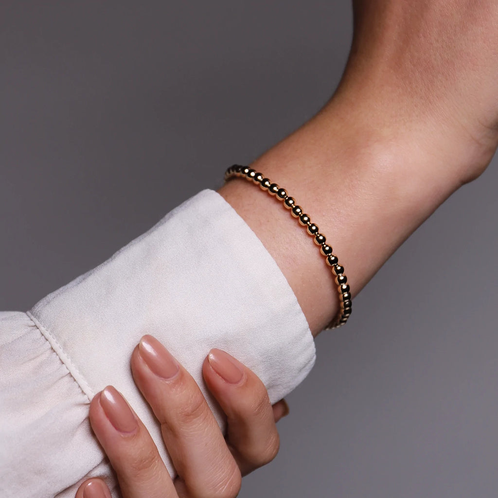 A woman's hand holding a Gold Ti Sento Milano Bracelet.