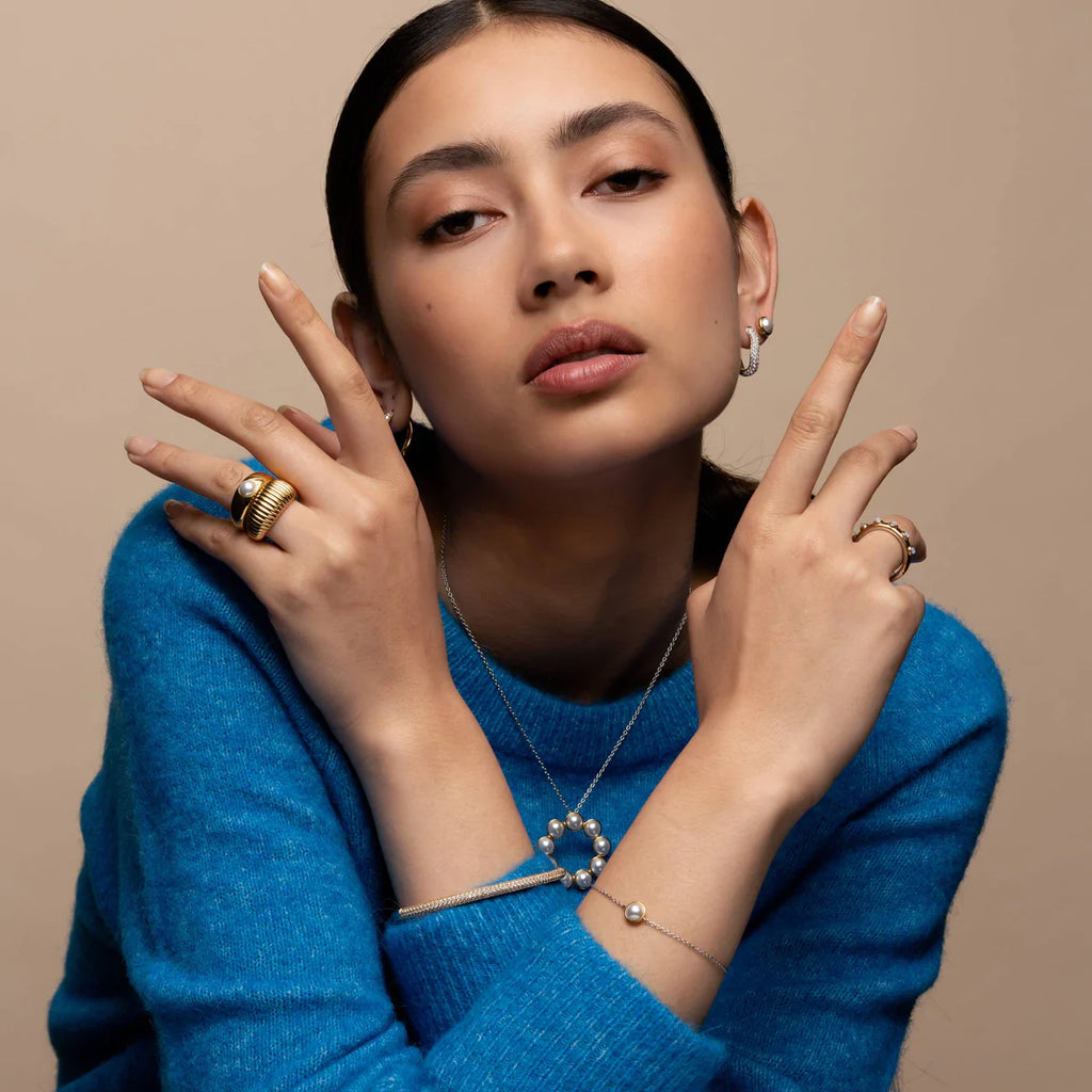 A woman wearing a blue sweater and a Pearl Ti Sento Milano Necklace.
