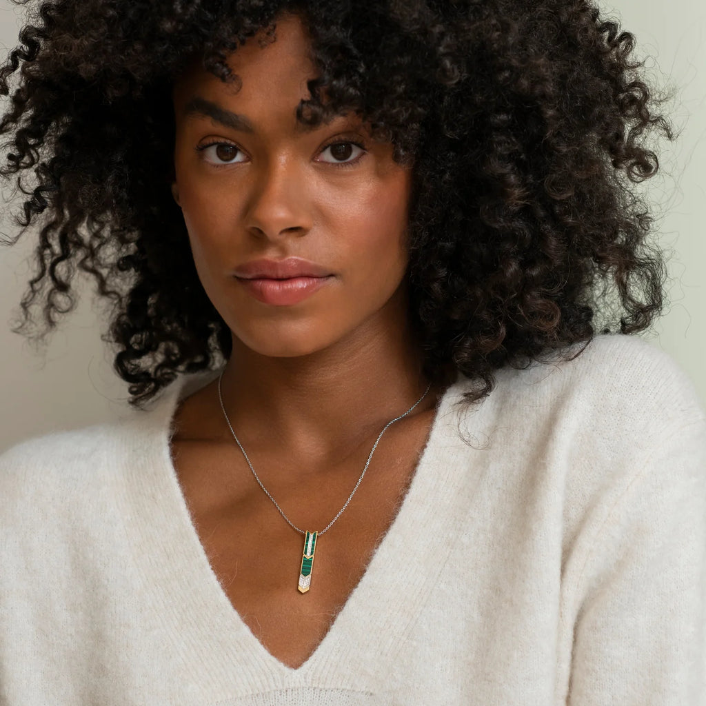 A woman with curly hair wearing a TI SENTO MALCHITE GREEN PENDANT 3954MA and a white sweater.