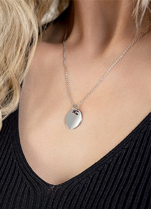 A woman wearing a silver necklace with a Clogau Celebration February Birthstone pendant.