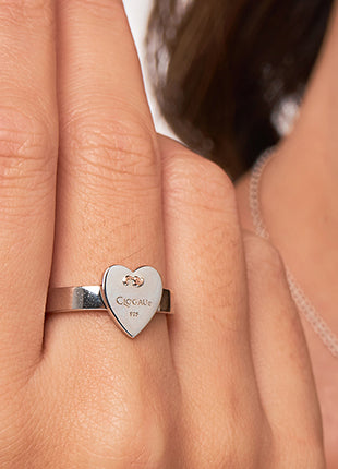A woman's hand is holding a Tree of Life Insignia Heart Ring 3SCSHLR.