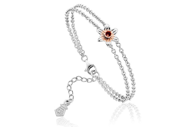 A Clogau Daffodil Bracelet 3SDMB with a red stone and a silver chain.