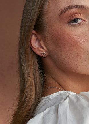 A woman in a white shirt is posing for a photo wearing the NEW Clogau Fairies of the Mine Stud Earrings 3SETL0232.