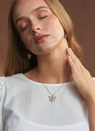 A woman wearing a NEW Clogau Fairies of the Mine White TopazPendant 3SETL0233 and a necklace.