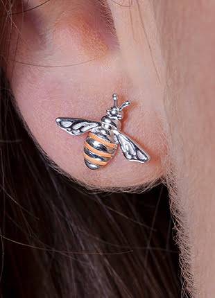 A woman's ear with a Clogau Honey Bee Earrings 3SHNBE.