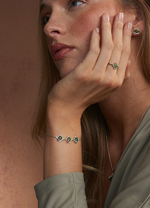 A woman wearing a NEW Clogau Ivy Leaf Green Jasper and White Topaz Bracelet 3SIVL0342 and ring.