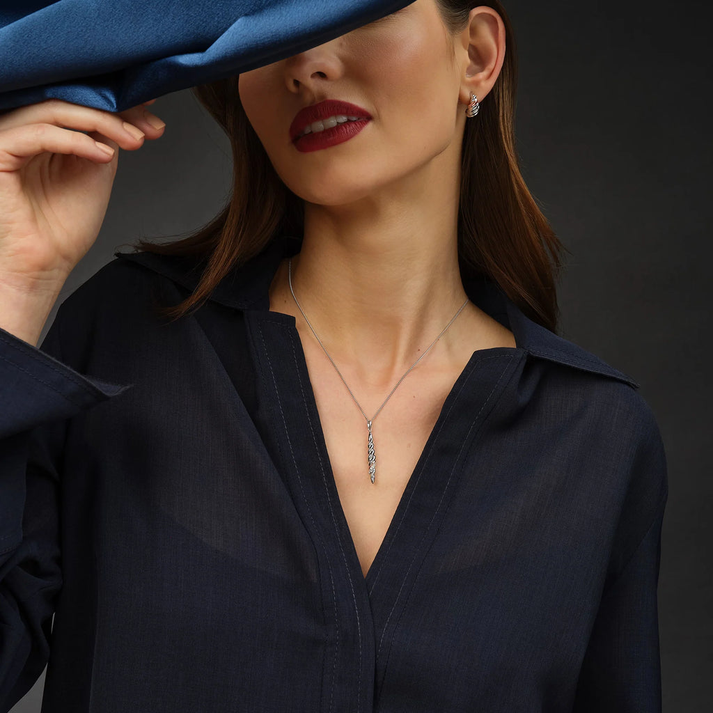 A woman in a blue shirt with the Clogau Lover’s Twist Pendant 3SLTW0613 on her head.