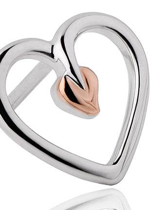 a silver and gold heart ring on a white background