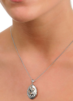 A woman wearing a CLOGAU Tree of Life® Diamond Locket 3STOLLP with a heart shaped pendant.