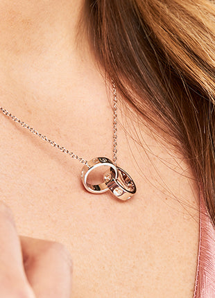 A woman wearing a Clogau Tree of Life Insignia Links Necklace 3STOLMNN with a heart shaped pendant.