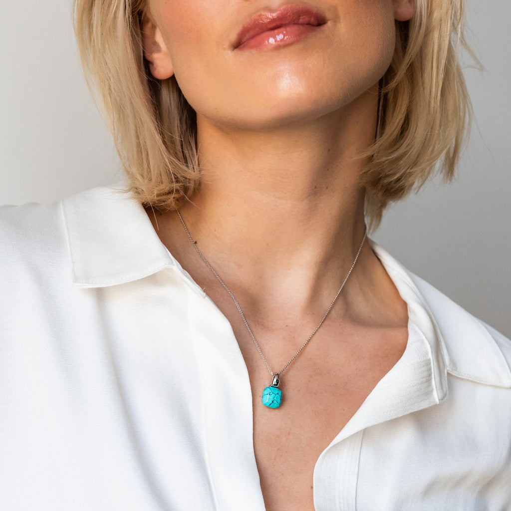 A woman wearing a TI SENTO Milano Pendant 6785GG necklace with a turquoise stone.