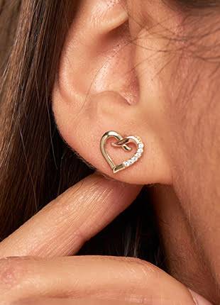 A woman's ear with a Clogau Kiss Diamond Stud Earrings CGKDSE.