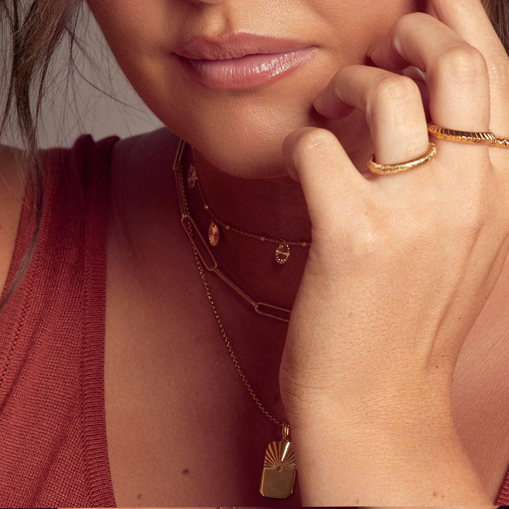 A woman is posing with a Hot Diamonds X Jac Jossa Embrace Twisted Wired Chain on her finger.