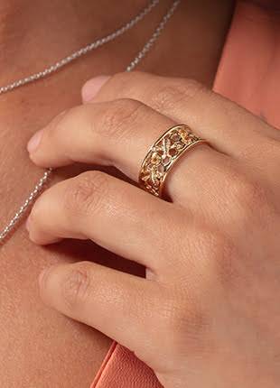 A woman wearing a Clogau Honey Bee Honeycomb Ring HNBWR and necklace.