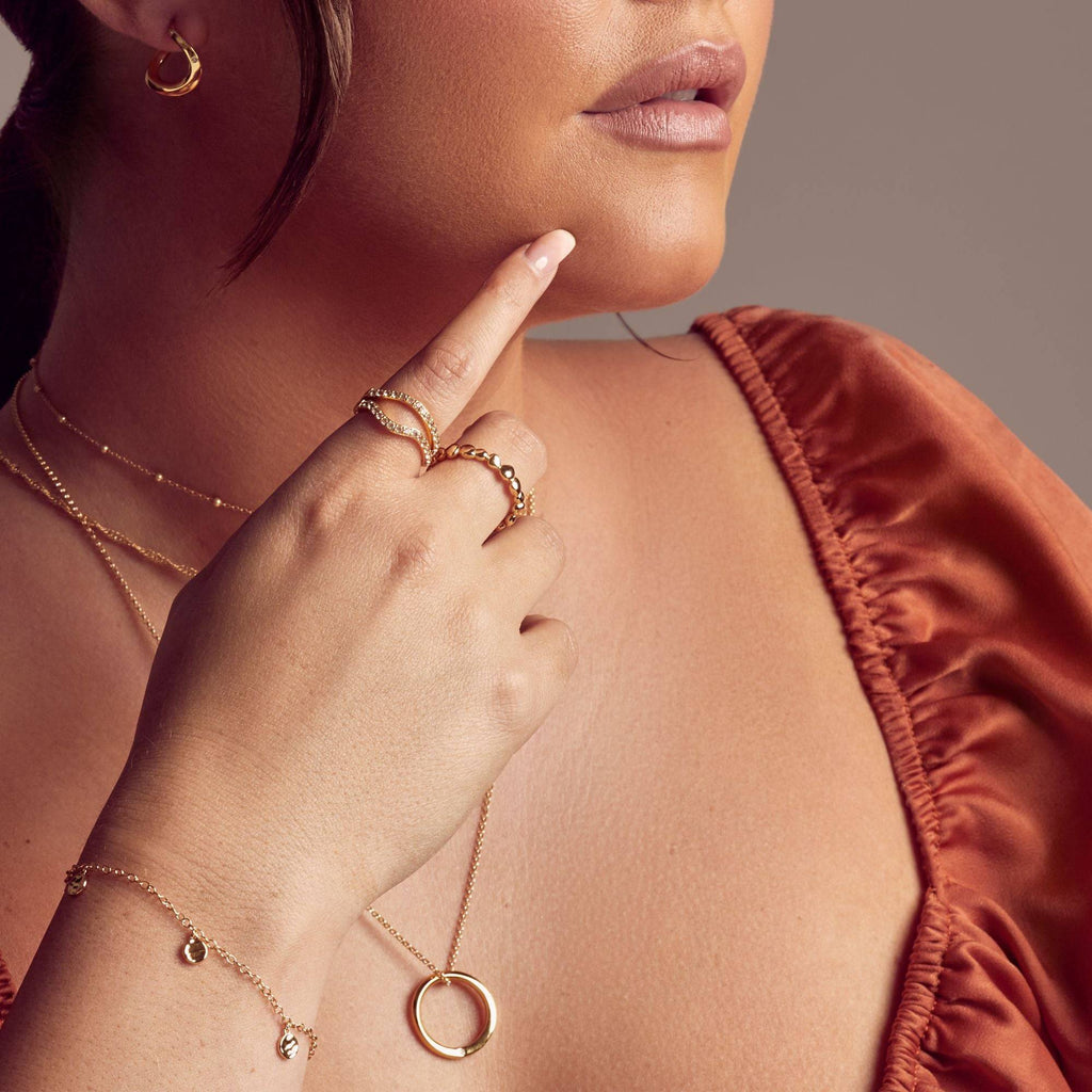 A woman wearing a HOT DIAMONDS X JAC JOSSA Soul Pendant necklace and ring.