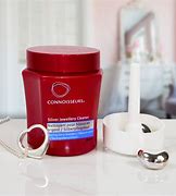 A red CONNOISSEURS SILVER JEWELLERY CLEANER with a red heart on top of it.