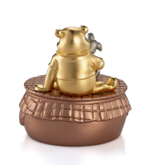 A Winnie the Pooh Music Carousel Limited Edition Gilt 016318E figurine sitting on top of a bowl.