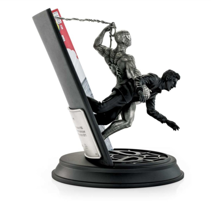 A statue of Limited Edition Spider-Man Amazing Fantasy #15 0179017 holding a book on a stand.