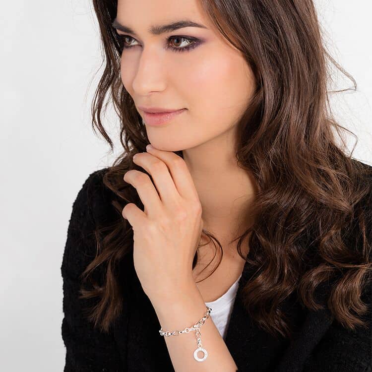 A woman wearing a Thomas Sabo Charm bracelet X0031-001-12.
