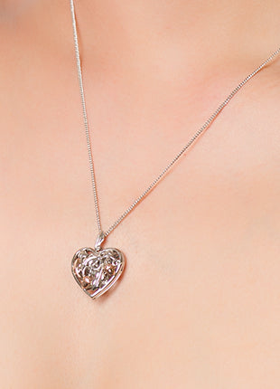 A woman wearing a Clogau Royal Clogau® Oak Heart Locket XX3STRP04 necklace.