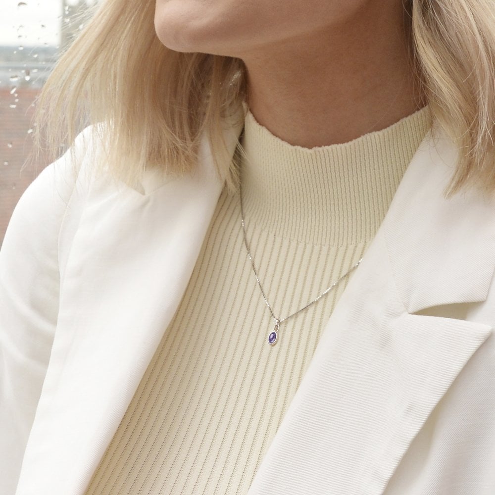 A woman wearing a white jacket and a February Birthstone Necklace - Amethyst.