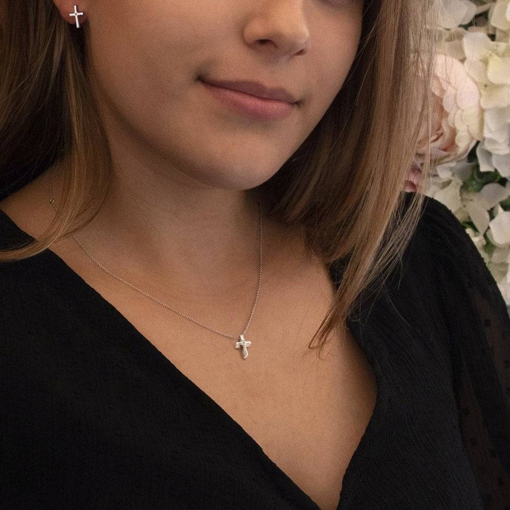 A woman wearing Diamond Amulet Cross Earrings.