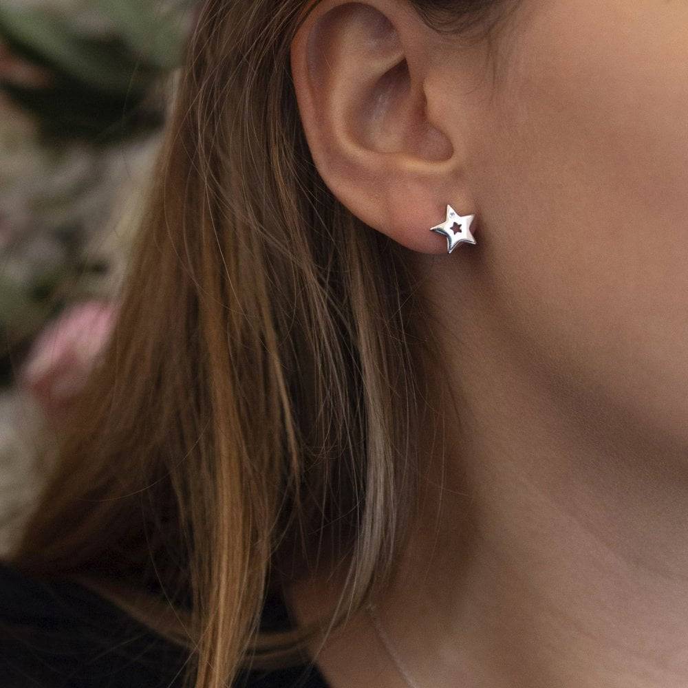 A woman wearing a pair of Diamond Amulet Star Earrings.